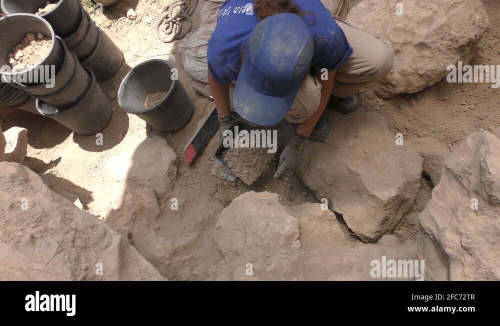 Female archaeologist archaeological excavation site digging artifacts