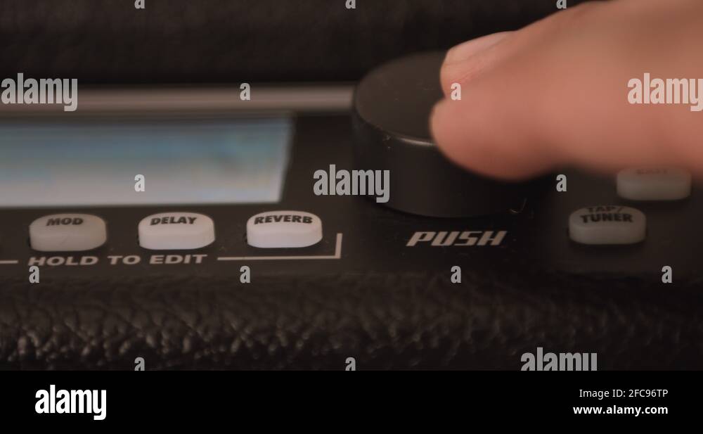 Musician Adjusting Knobs On Guitar Solid State Amp. Dolly Shot Stock
