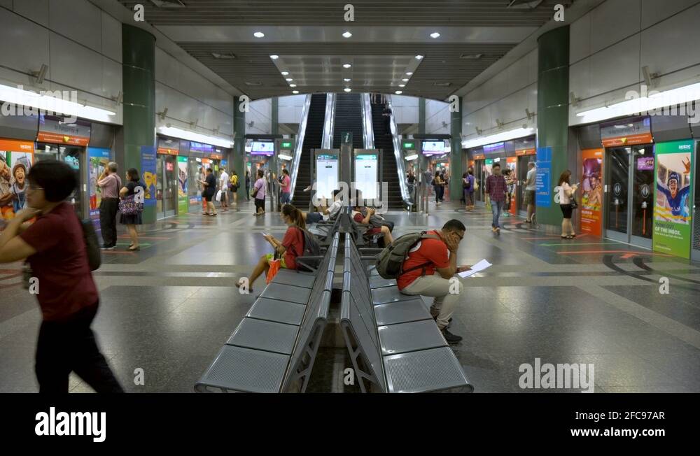MRT Train Arriving at Subway Station Behind Platform Screen Doors in Singapore Stock Video