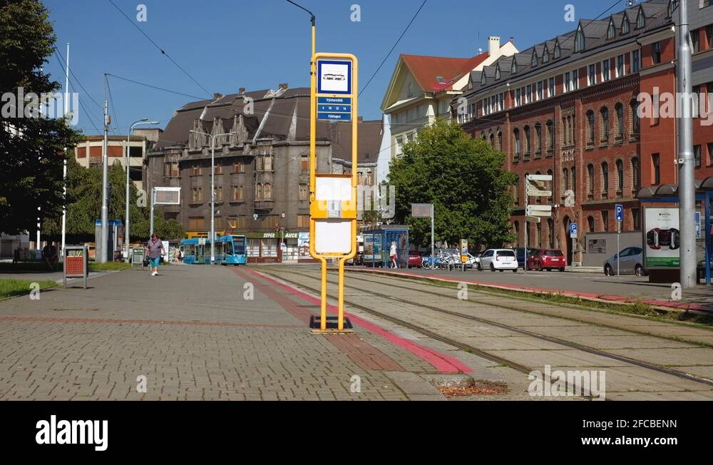 Ostrava - Street view with tram arriving at stop and people getting on ...