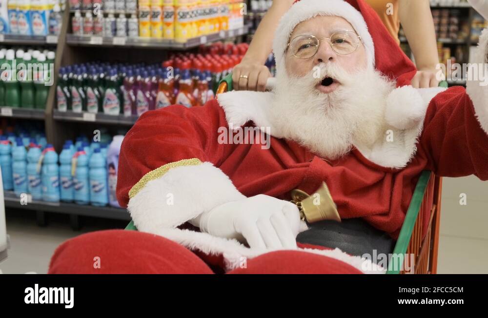 Santa Claus doing grocery shopping at the supermarket, he is inside a
