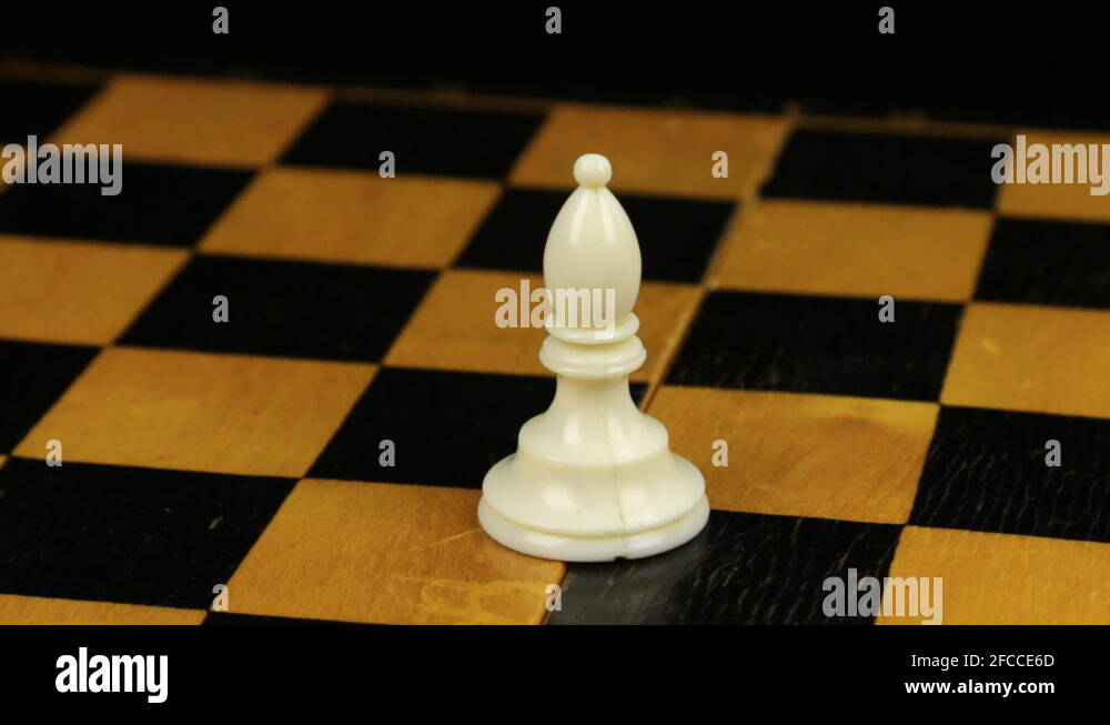 Small Rotation Chess Rotation. Chess figure white bishop on chess board. Close-up Stock ...
