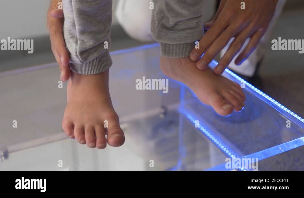 Closeup shot of child's feet on a glass surface while a podiatric