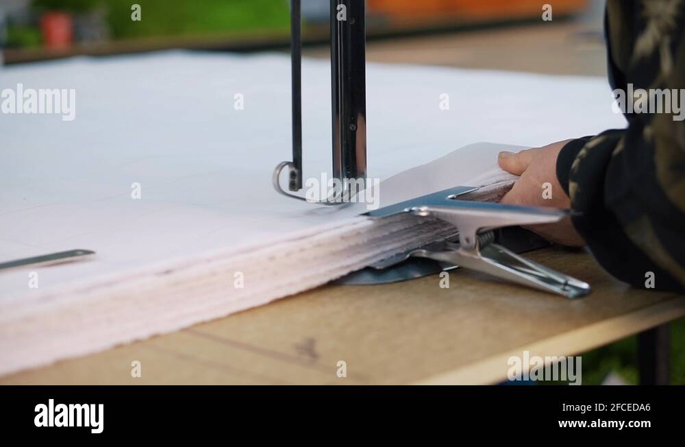 Woman works behind weaving knife, cuts thick pile of fabric in given dimensions Stock Video