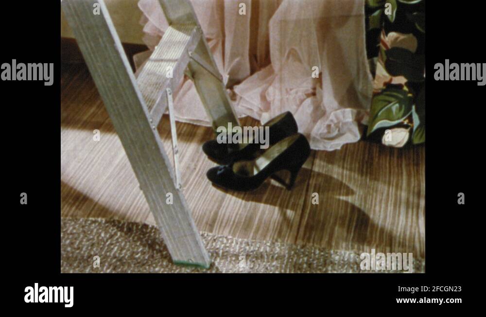 1950s: UNITED STATES: shoes at bottom of ladder. Lady up ladder. Lady ...