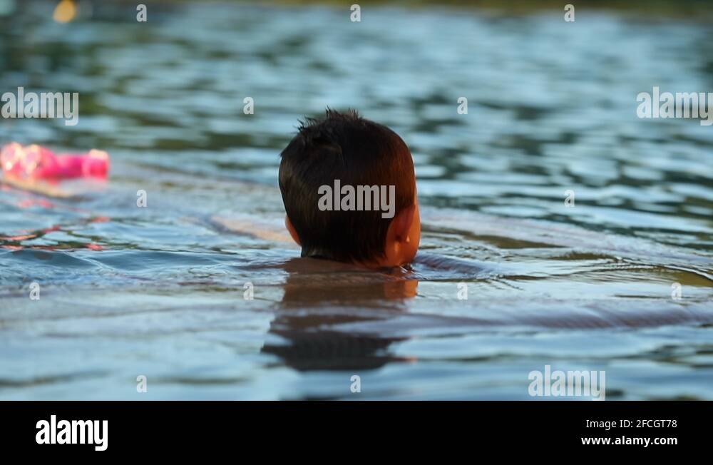 Back of contemplative thoughtful little boy at the swimming pool