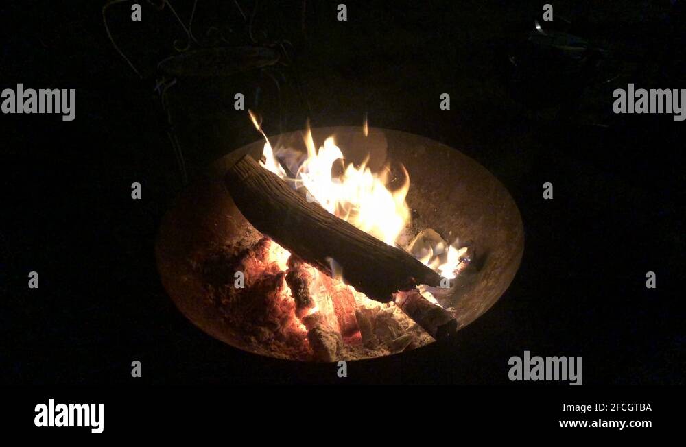 Logs burning in a fire bowl on a pitch black night Stock Video Footage Alamy