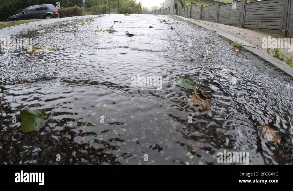 Rainwater flows beautifully down a paved mountain, in slow motion Stock