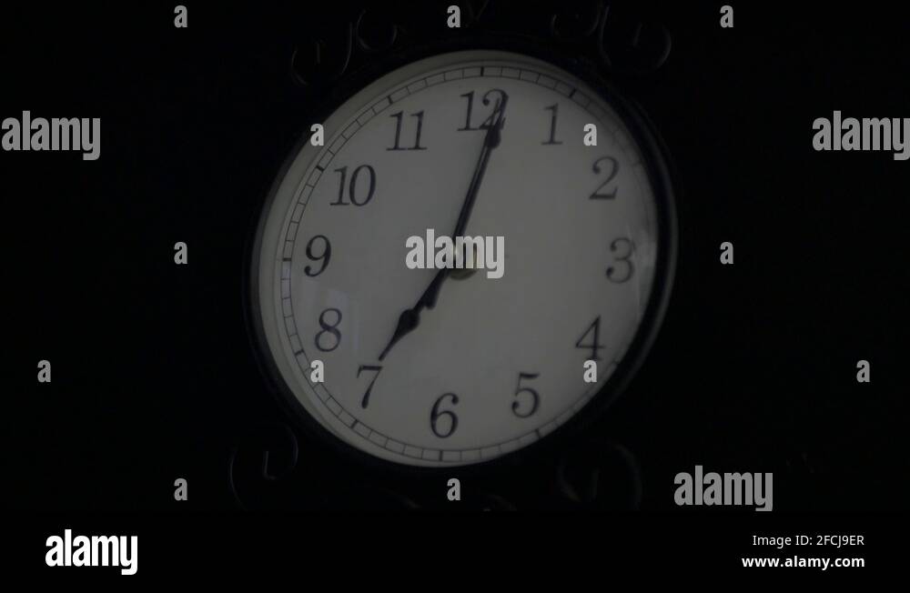 A Small Black Clock Ticking in Complete Darkness Stock Video Footage