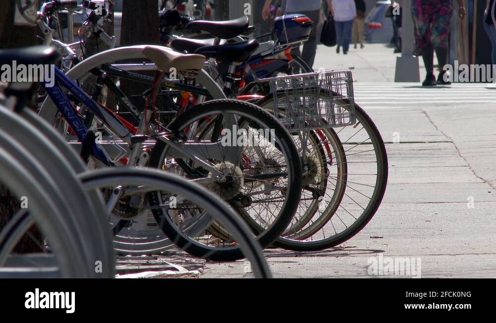 Abandoned bicycle frame locked to bike rack with stolen wheels. Parts