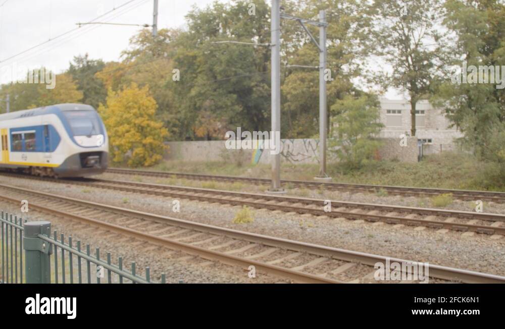 Dutch train driving over railway and picking up speed Stock Video