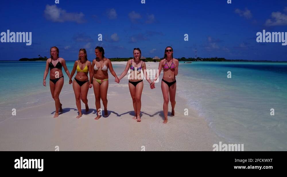 Girls in Bikini Walking Down a Long Stretch of Beach in Malaysia