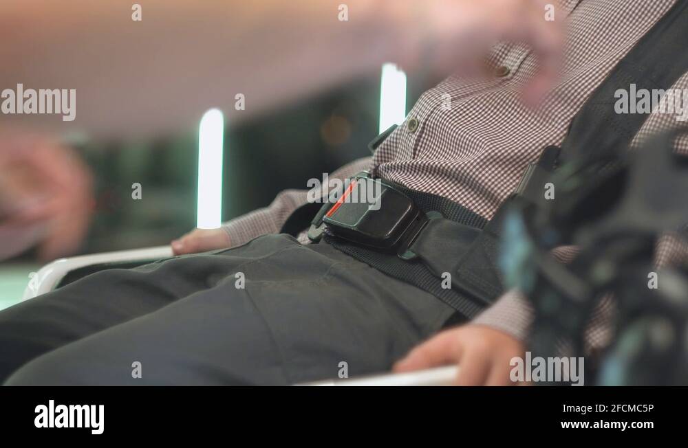Woman fastens seat belt on virtual reality setup. View of a passenger boy with Stock Video