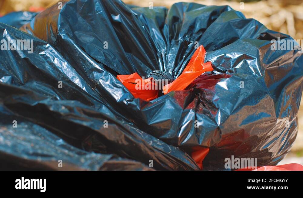 Black plastic bin bags with red ties on the ground Stock Video Footage Alamy