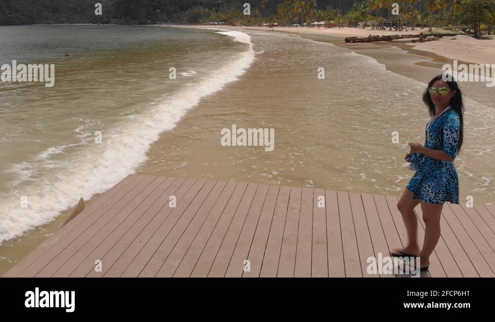 A woman walks out on a jetty on the most famous beach Maracas located