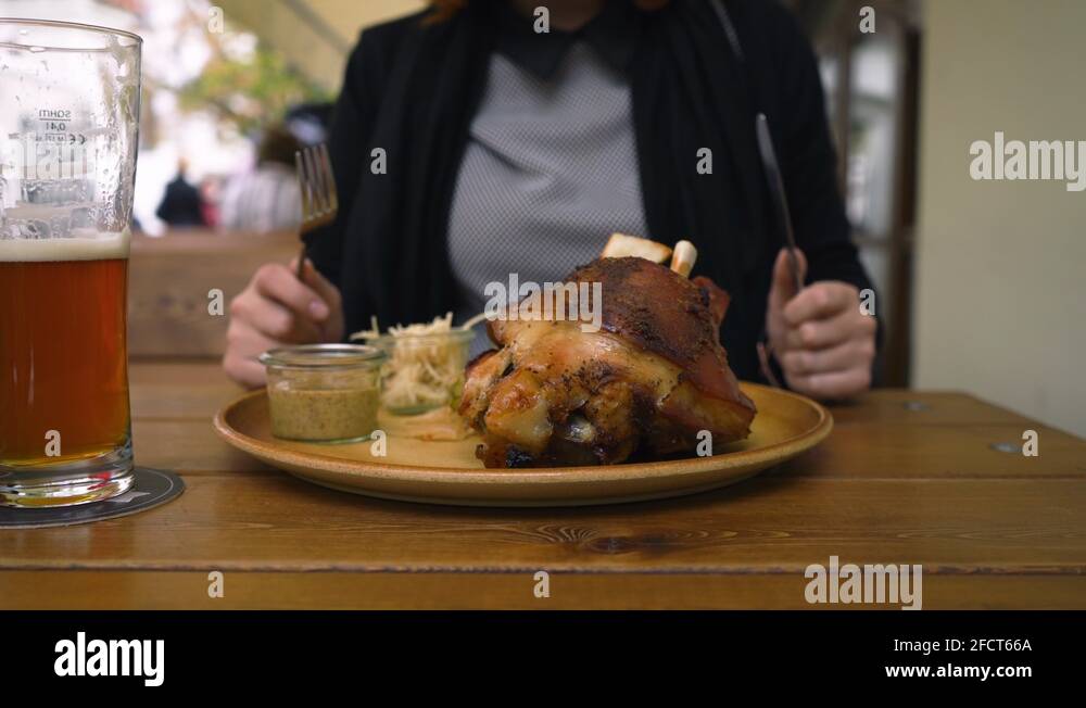 Woman enjoying traditional Czech food Roasted pork knee knuckle