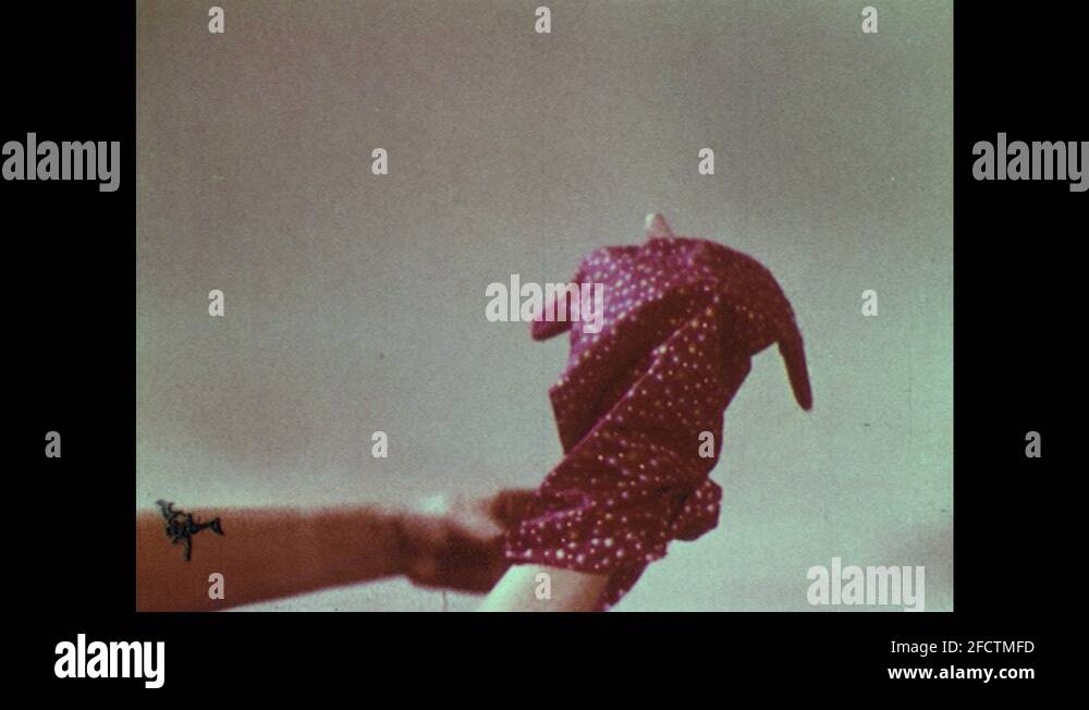 1950s Person puts hand inside puppet dress and sticks puppet head on