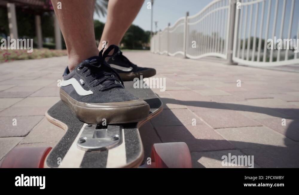 a boy and a longboard with a front view of his skateboard wheels in
