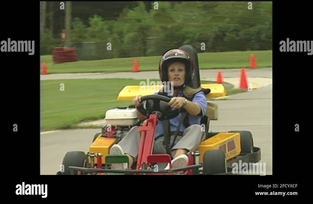 1990s Boy and girl drive go carts on race track. Girl drives go cart