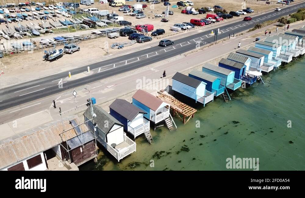 Thorpe bay seafront Essex pan left showing sea beach huts cars sail