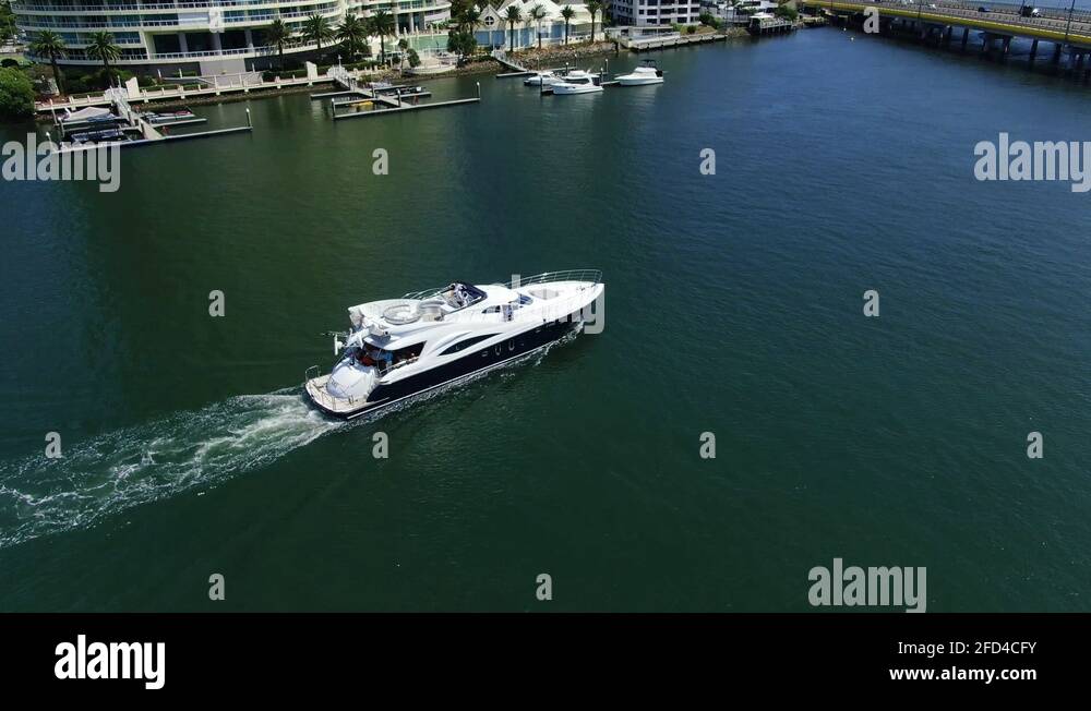 Luxury yacht cruises down Gold Coast waterway on a bright summers day