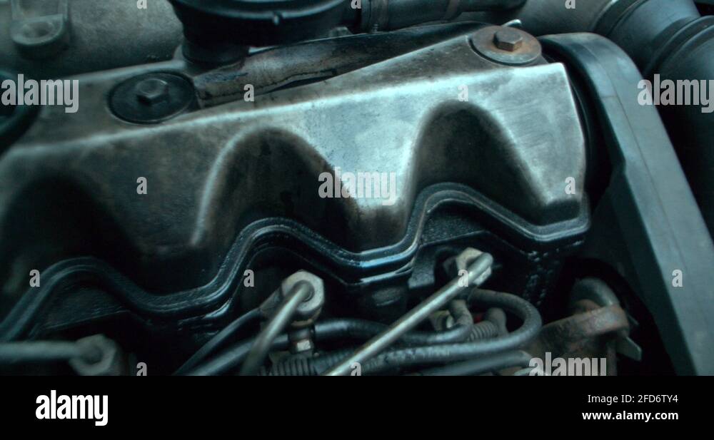 Working engine of the old car under the open hood. oil leakage Stock