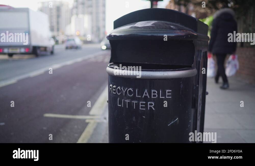 A black recyclable trash bin near the road in london Stock Video