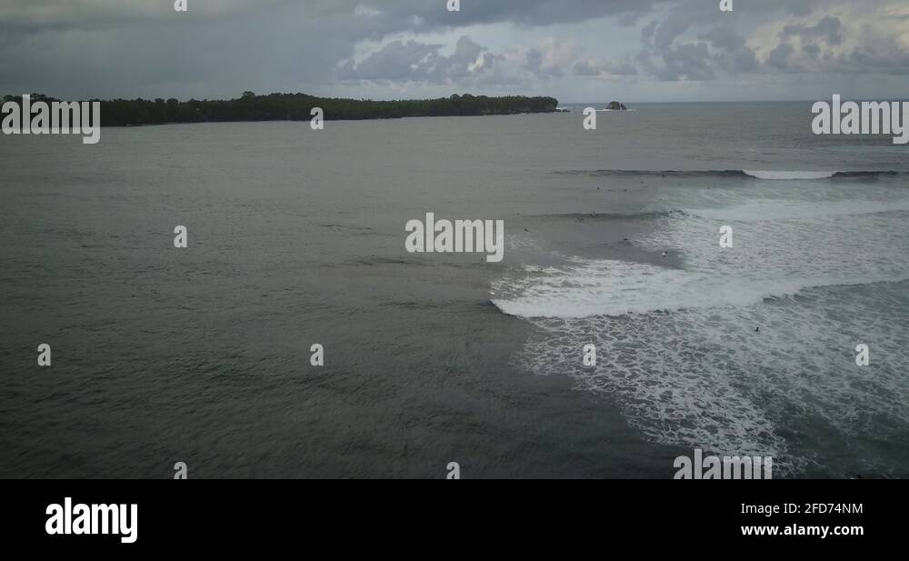 aerial Men surfing longboard at a surf spot in the philippines from