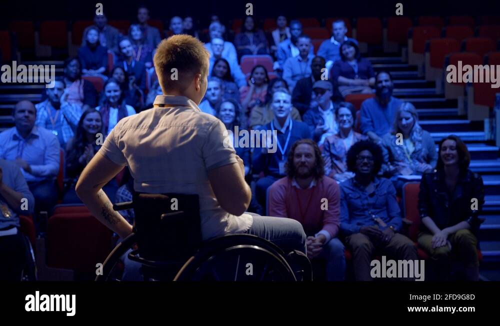Audience clapping for confident female inspirational speaker in