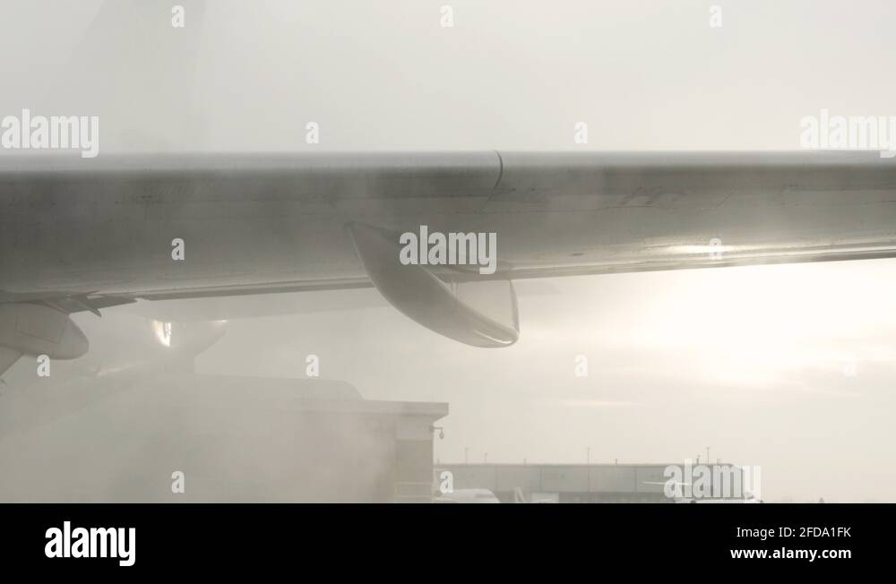 Deicing chemical spray applied to airplane wing prior to takeoff Stock