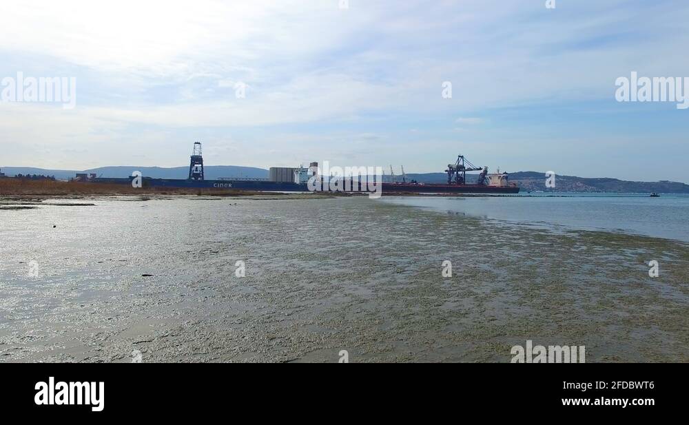 Seashell lined beach of Pokopalisce skoljk with Tanker ships in the