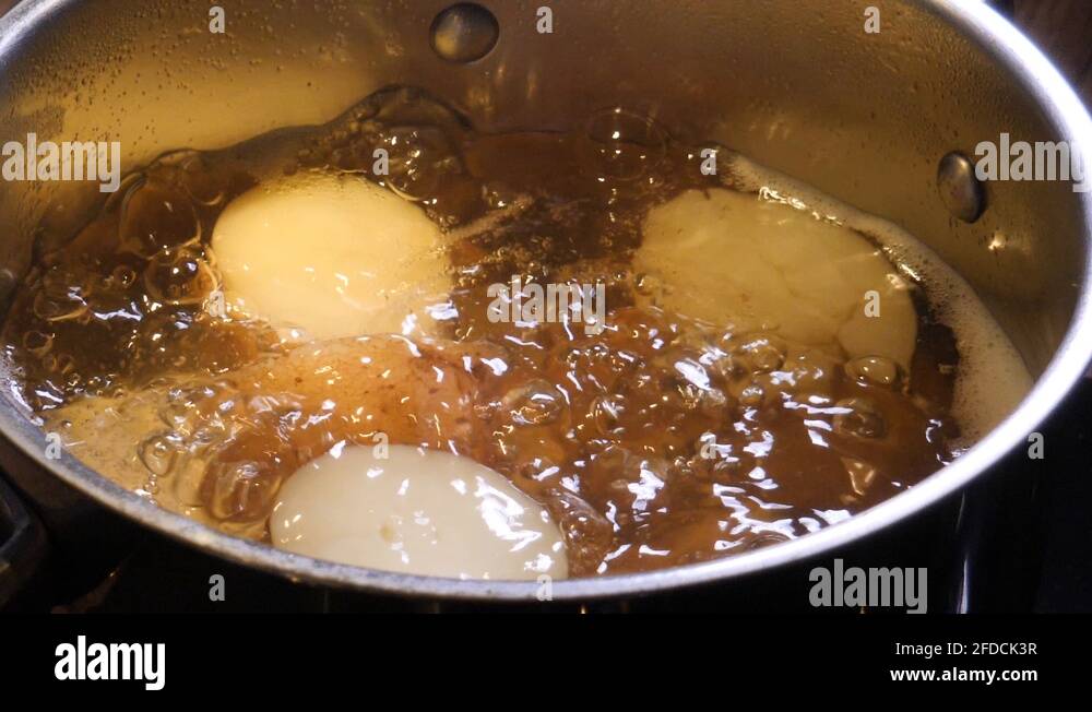 Potatoes boiling in water on the stove in a large pot slow motion