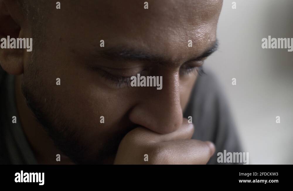 Asian Male Rocking Back And Forth With Hand In Front Of Mouth Looking