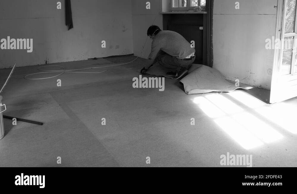 removing old dusty carpet in the empty house room during general