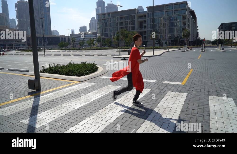 Young girl jumping by crosswalk with jump rope with urban background of