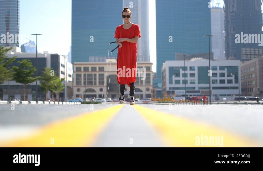 Young girl jumping with jump rope with cityscape background of Dubai in
