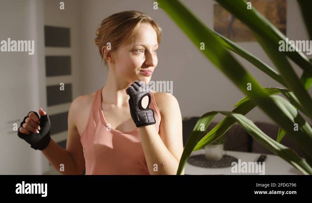 A woman standing bending elbows turning her upper body to left and