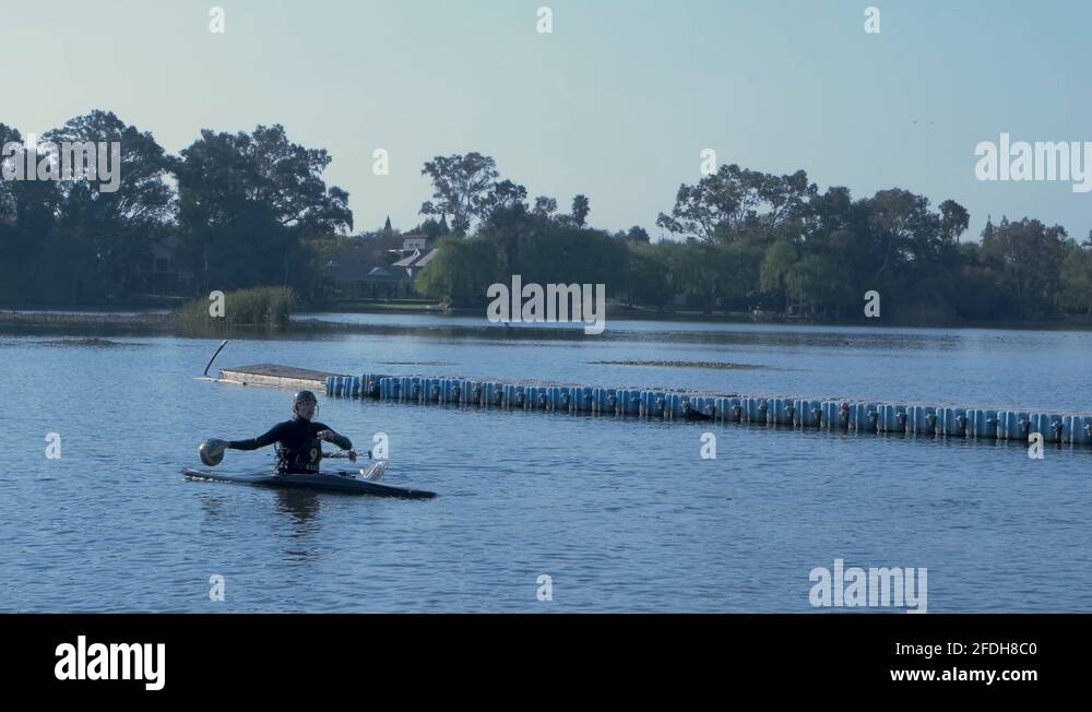 Canoe polo player in a boat scoring a goal in a net Stock Video Footage