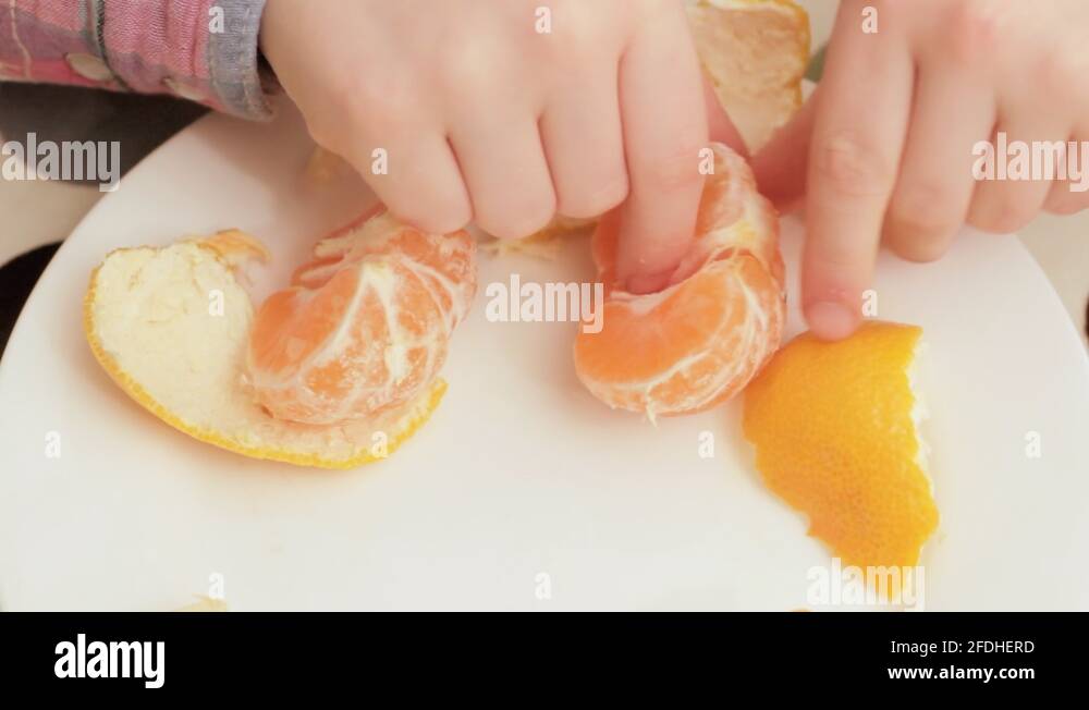 Little girl eating satsuma Stock Video Footage Alamy