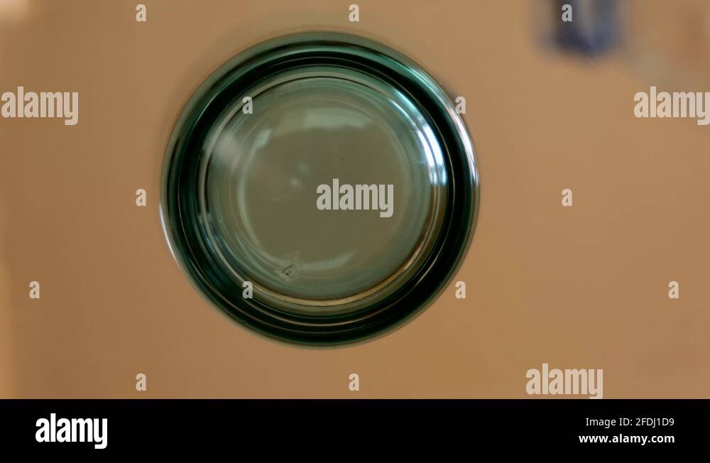 Sparkling water pouring into glass view from below. Under glass table