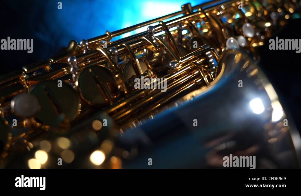 Golden shiny alto saxophone with blue smoke. Concept of grace and