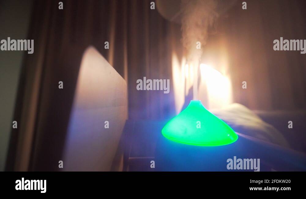 Steaming neon glowing aromatherapy mist vaporizer at hotel room. Misty