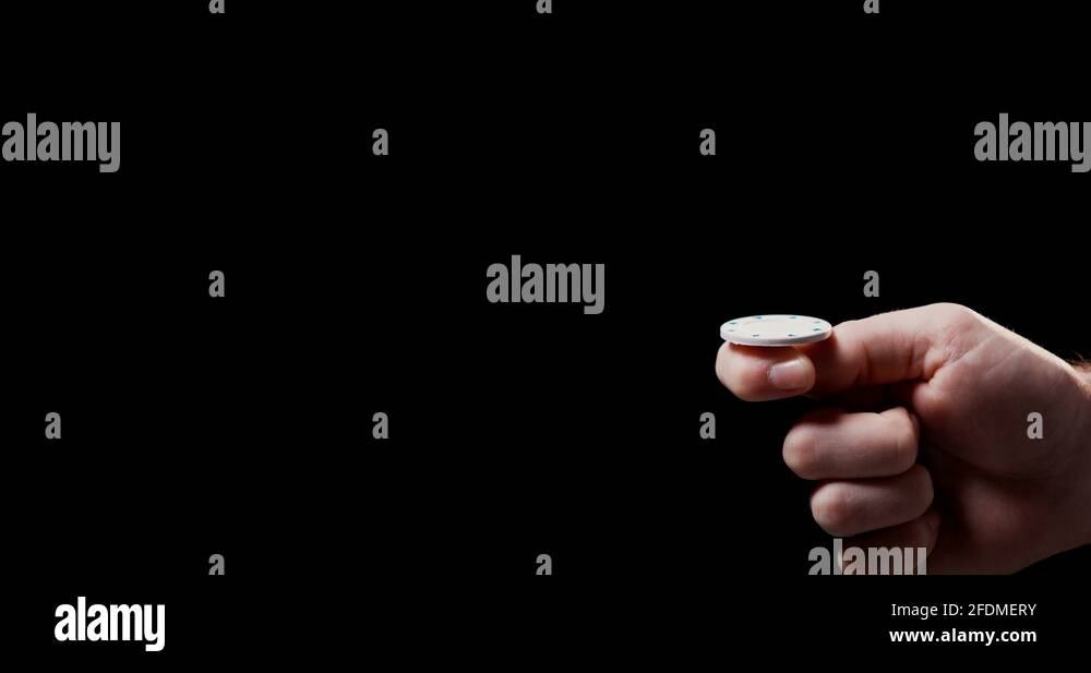 Close up of male hand flipping white poker chip with black background