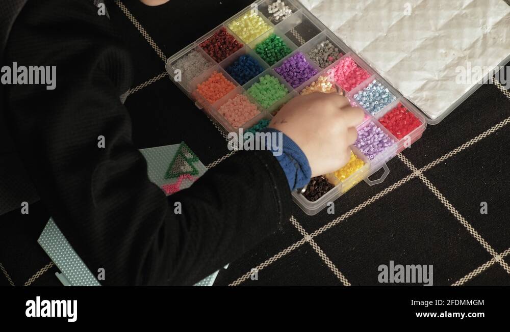 child plays with perler beads. fine motor development Stock Video
