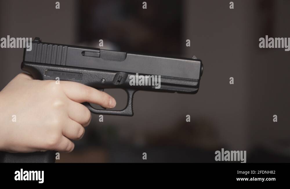 Young Boy Pointing A Nine Millimter Gun And Pulling The Trigger Close 
