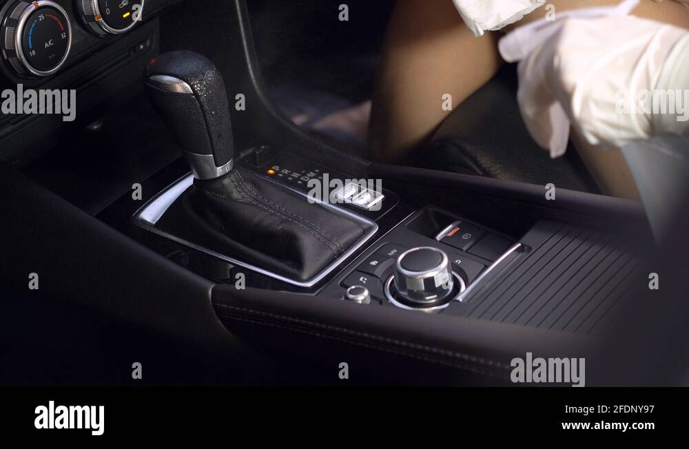 White gloves hand wiping car interior, spray wipe inside car