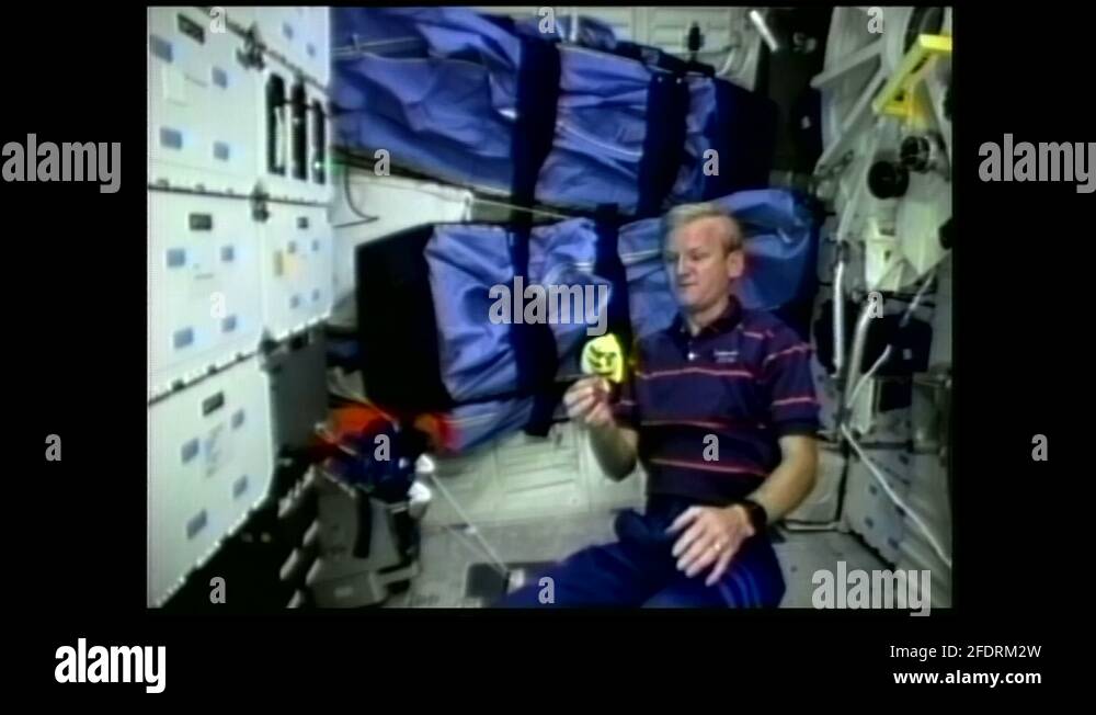 1990s astronaut floating in zero gravity releases mechanical toy fish