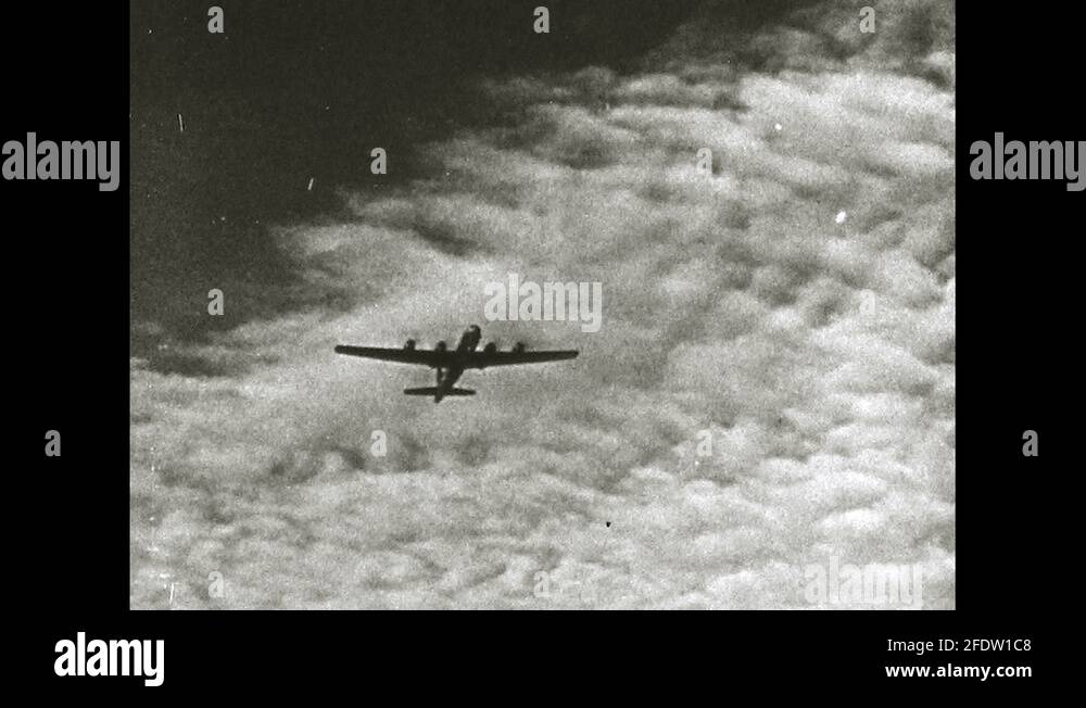 1960s: military plane seen from below flies through cloud-filled sky ...