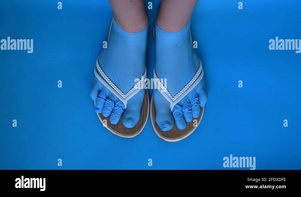 A girl’s feet in sterile disposable gloves dressed as socks and shale