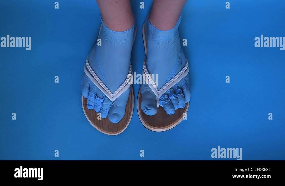 A girl’s feet in sterile disposable gloves dressed as socks and shale